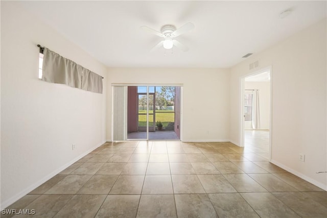 tiled spare room with a ceiling fan, visible vents, and baseboards