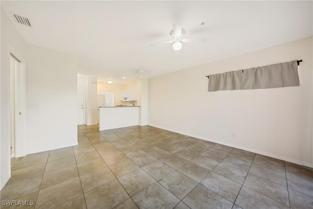 unfurnished room featuring baseboards, tile patterned flooring, visible vents, and a ceiling fan