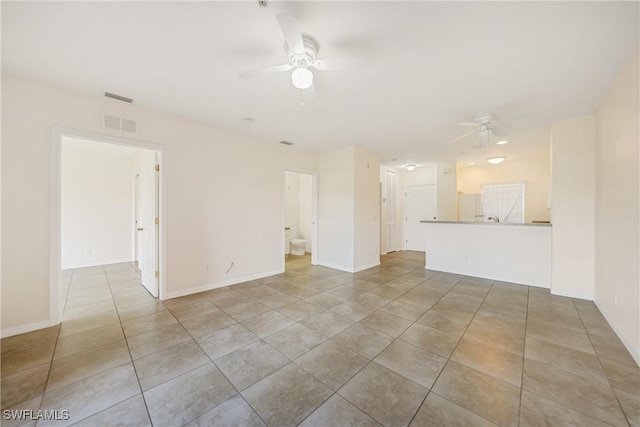 unfurnished living room featuring visible vents, ceiling fan, baseboards, and tile patterned floors