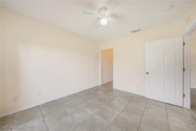 spare room with a ceiling fan, visible vents, baseboards, and light tile patterned flooring