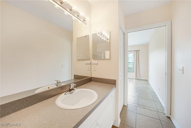 bathroom featuring tile patterned flooring, vanity, and baseboards