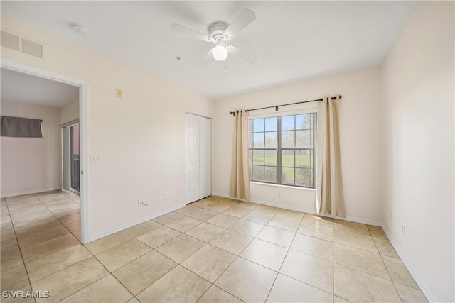 spare room with visible vents, ceiling fan, baseboards, and light tile patterned floors