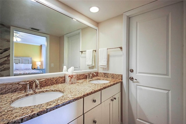 ensuite bathroom featuring ensuite bathroom, double vanity, a sink, and visible vents