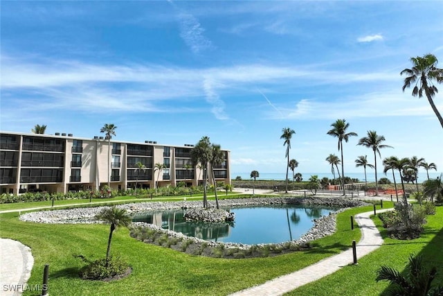 view of swimming pool featuring a lawn and a water view