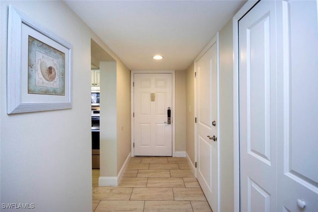 doorway featuring recessed lighting and baseboards