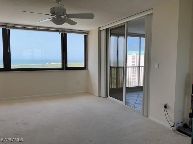 carpeted empty room featuring ceiling fan and baseboards