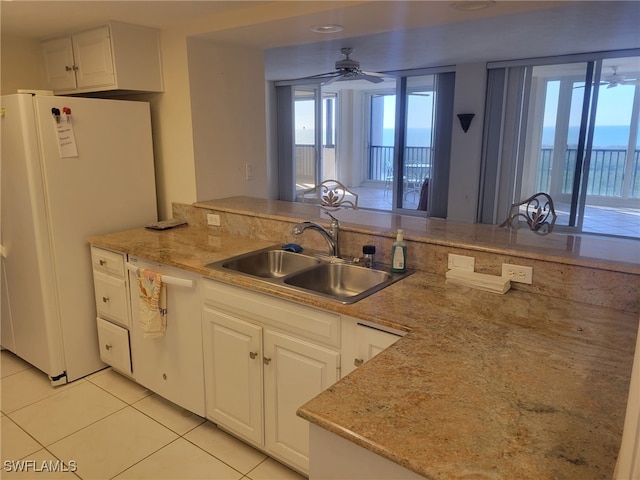 kitchen featuring light tile patterned flooring, white appliances, a sink, a ceiling fan, and white cabinetry