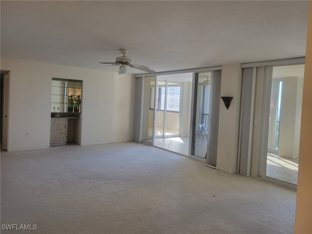 empty room with carpet and a ceiling fan