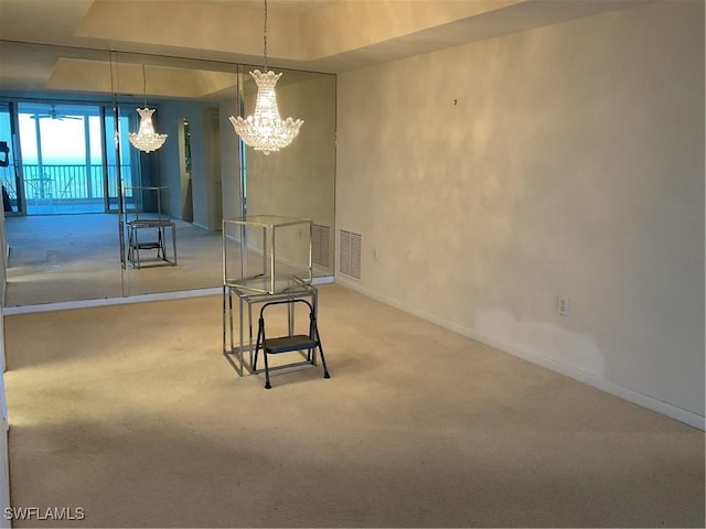 dining area featuring a tray ceiling, carpet flooring, visible vents, and baseboards