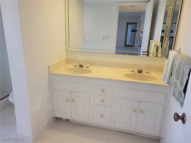 full bath featuring double vanity, baseboards, a sink, and tile patterned floors