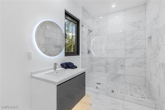 full bathroom with tiled shower and vanity