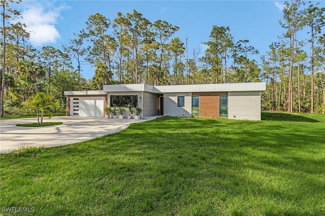 contemporary house with a front yard, concrete driveway, and an attached garage