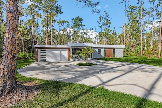 view of front facade featuring driveway, an attached garage, and a front yard