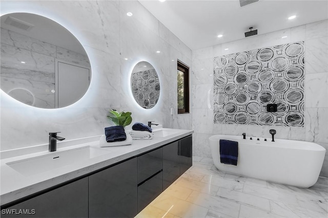 bathroom featuring marble finish floor, a sink, and tile walls