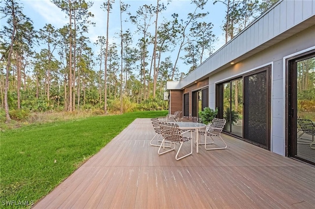 wooden terrace with a yard and outdoor dining space