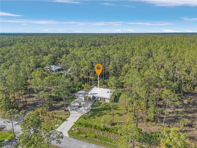 birds eye view of property featuring a forest view