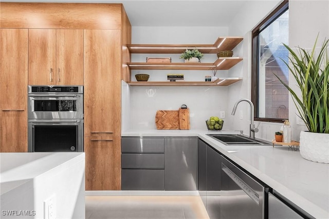 kitchen featuring light countertops, appliances with stainless steel finishes, modern cabinets, and a sink