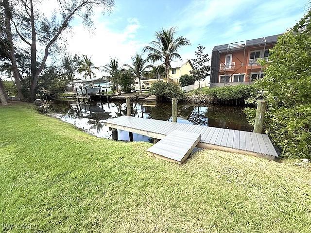 view of dock featuring a water view and a lawn