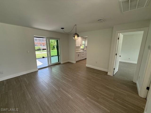 interior space featuring dark wood-style floors, visible vents, and baseboards