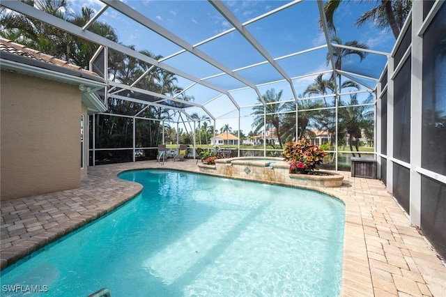 pool with glass enclosure, a patio area, and an in ground hot tub