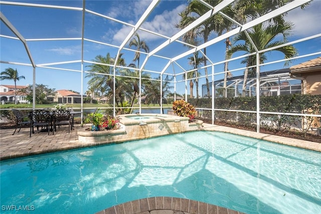 pool featuring glass enclosure, an in ground hot tub, and a patio