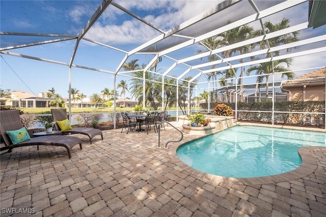 pool with glass enclosure, a patio, and a water view