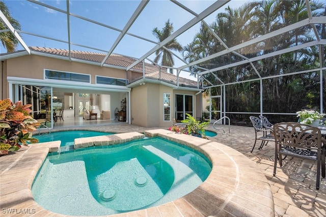 view of swimming pool with a patio area, a pool with connected hot tub, and glass enclosure