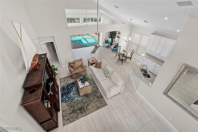 living area with high vaulted ceiling, a chandelier, and recessed lighting