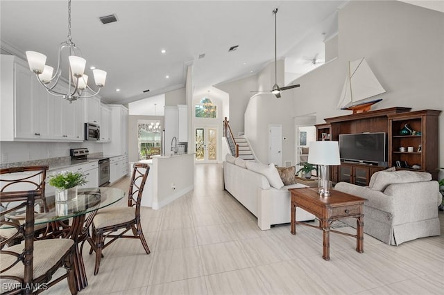 living area featuring recessed lighting, visible vents, stairway, high vaulted ceiling, and ceiling fan with notable chandelier