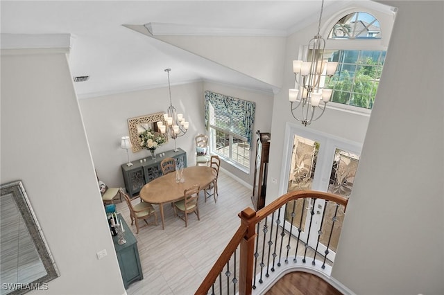 dining room featuring french doors, crown molding, a notable chandelier, lofted ceiling, and baseboards