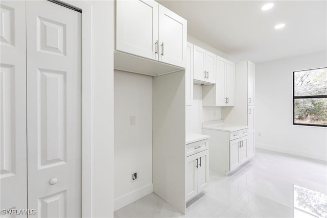 kitchen featuring baseboards, white cabinetry, light countertops, and recessed lighting