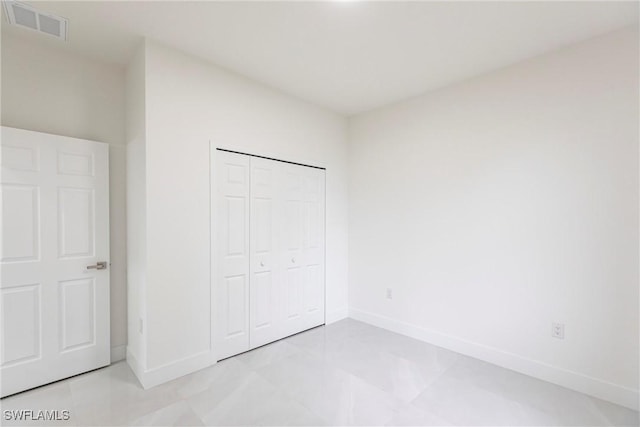 unfurnished bedroom featuring a closet, visible vents, and baseboards