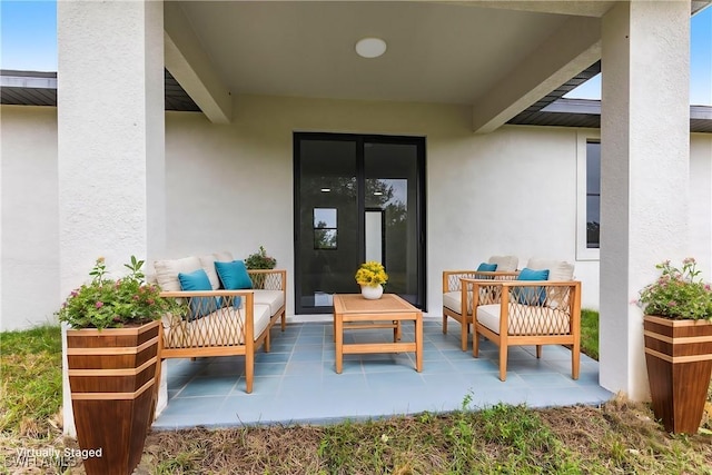 doorway to property featuring outdoor lounge area, a patio, and stucco siding