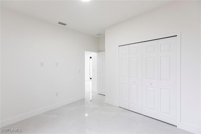 unfurnished bedroom featuring a closet, visible vents, and baseboards