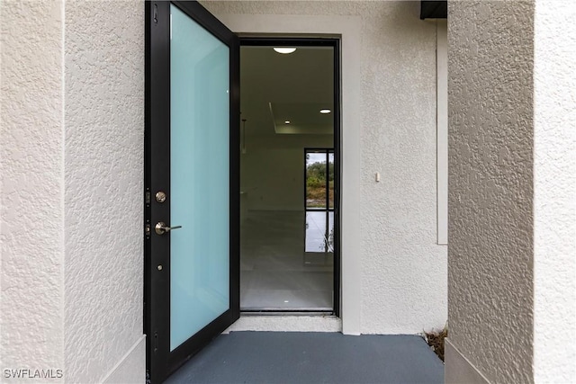 view of exterior entry with stucco siding