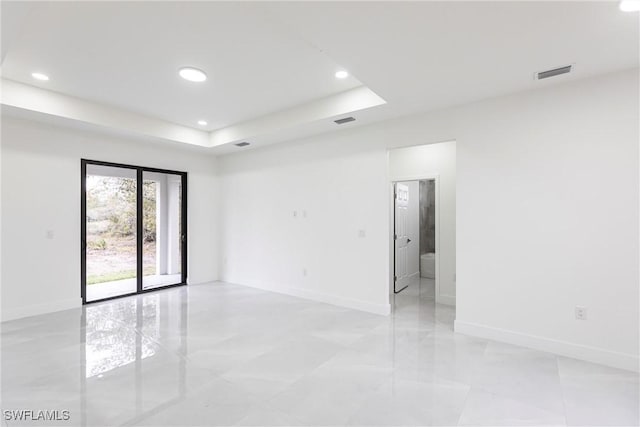 unfurnished room featuring visible vents, a tray ceiling, baseboards, and recessed lighting