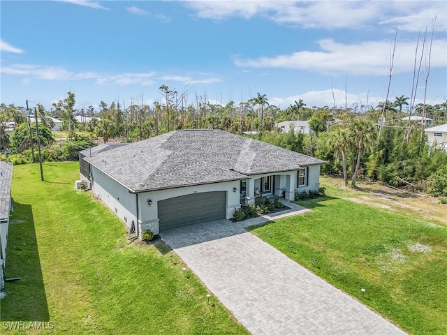 single story home with a garage, a front lawn, decorative driveway, and stucco siding