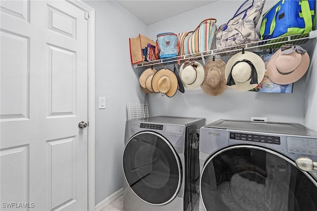 laundry area with laundry area, separate washer and dryer, and baseboards