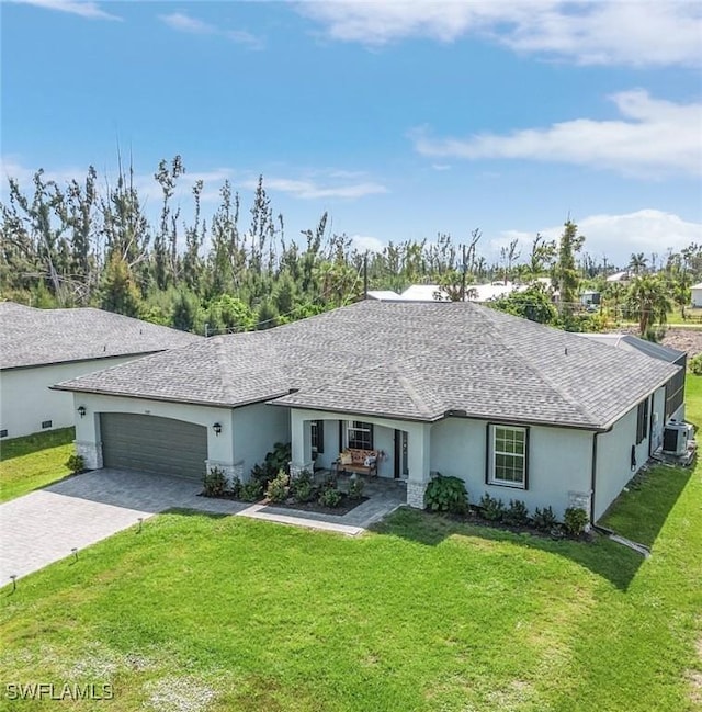 ranch-style home featuring a garage, a front lawn, decorative driveway, and stucco siding