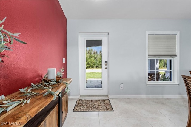 foyer entrance featuring light tile patterned floors and baseboards