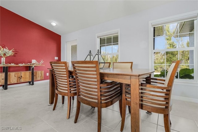 dining room featuring baseboards and vaulted ceiling