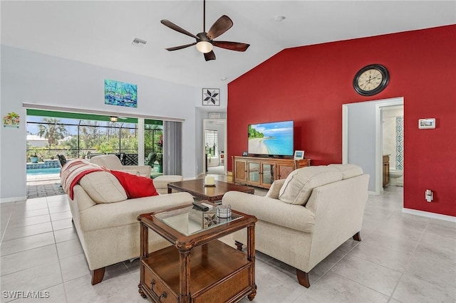 living room with high vaulted ceiling, light tile patterned flooring, an accent wall, visible vents, and a ceiling fan