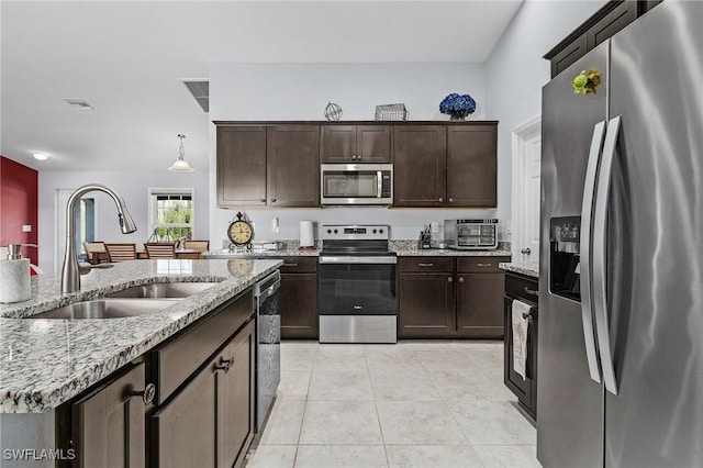 kitchen featuring decorative light fixtures, visible vents, appliances with stainless steel finishes, light tile patterned flooring, and a sink