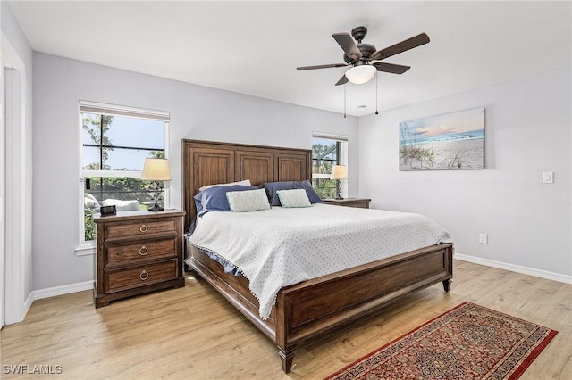 bedroom with light wood-type flooring, baseboards, and a ceiling fan