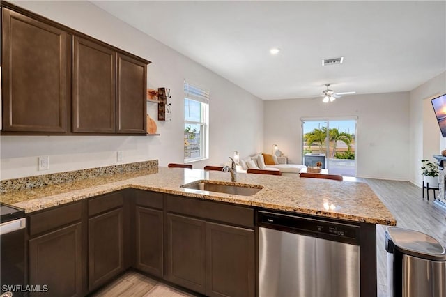 kitchen featuring visible vents, dishwasher, open floor plan, a peninsula, and a sink