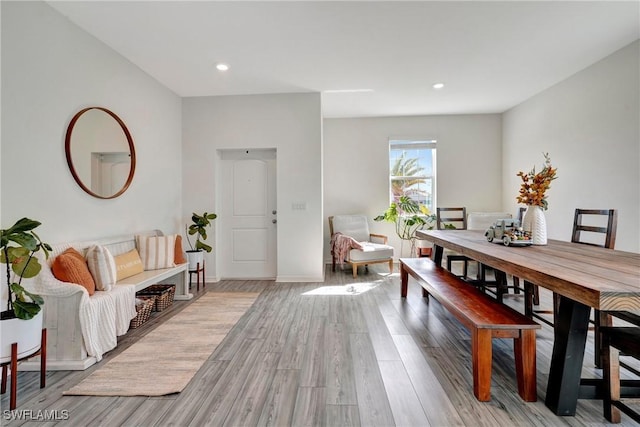 dining space featuring baseboards, wood finished floors, and recessed lighting