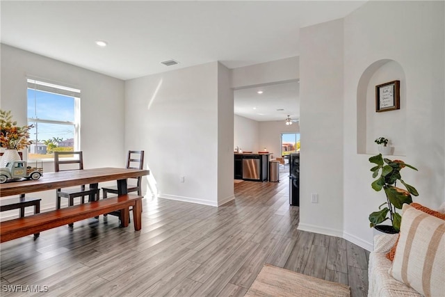 dining area featuring a healthy amount of sunlight, light wood-style flooring, and baseboards