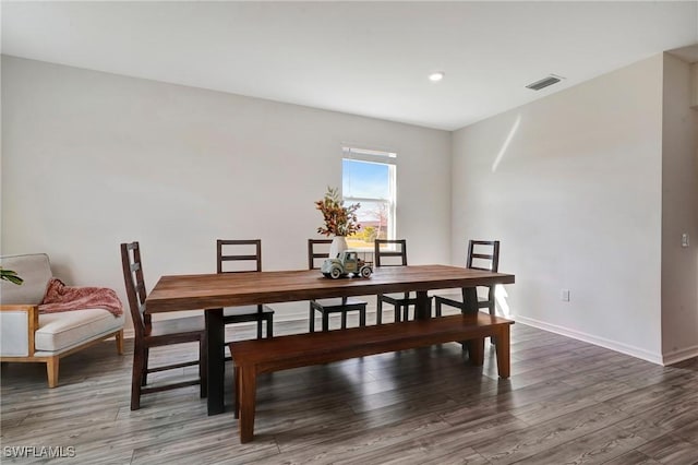 dining area with visible vents, baseboards, and wood finished floors