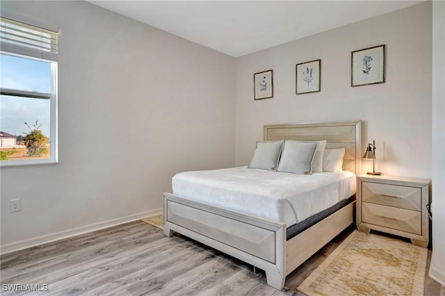 bedroom featuring light wood-style floors and baseboards