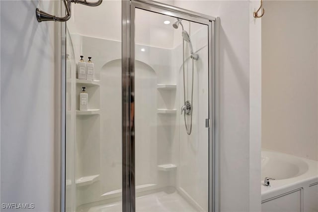 full bath featuring a garden tub and a shower stall